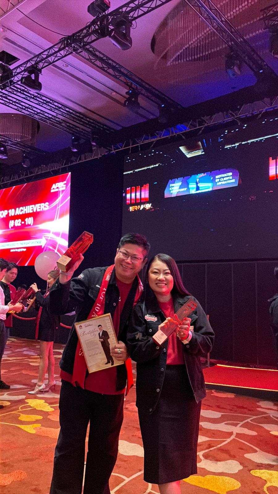 Christopher and Jasmine holding Top 10 Achievers trophies