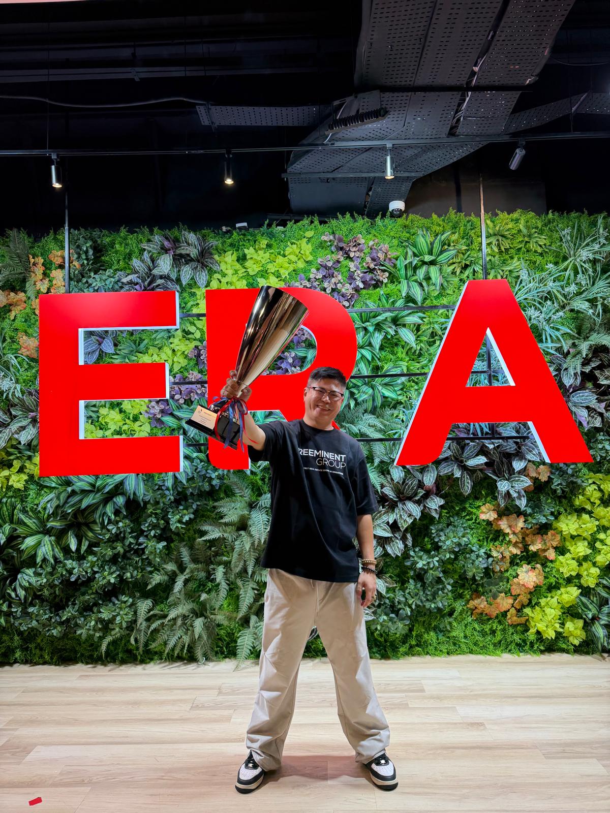 Christopher with trophy in front of ERA wall